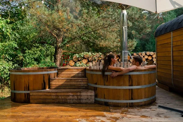 para kąpiąca się w tradycyjnej balii ogrodowej z piecem na drewno