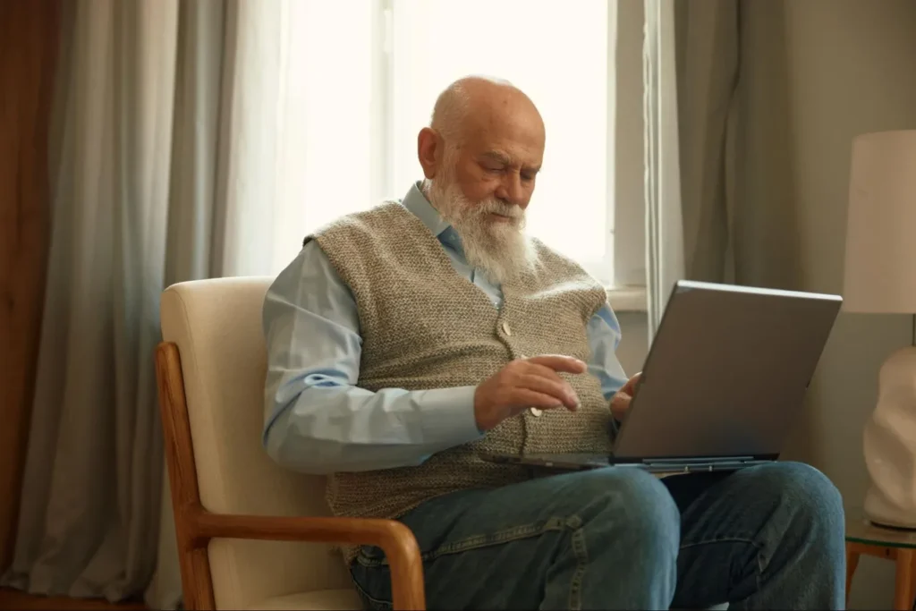 starszy mężczyzna korzystający z laptopa